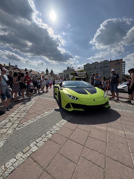 Zielone Lamborghini Huracan podczas pikniku charytatywnego Fundacji FunAndDrive Dzieciom na placu miejskim w słoneczny dzień